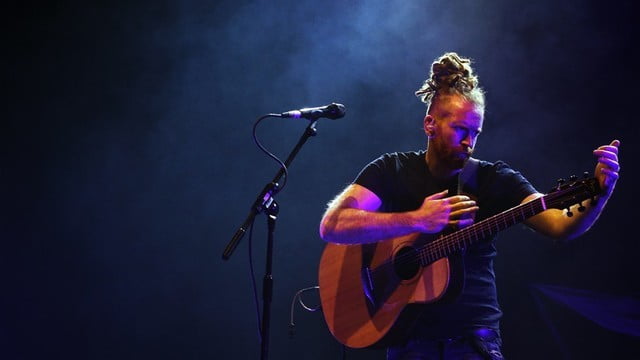 Newton Faulkner Performing on Stage with Guitar